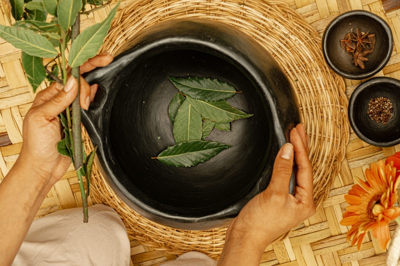 Manos preparando plantas medicinales en un taller de herbolaria